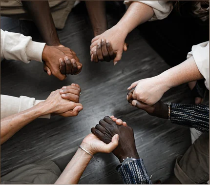 People joining hands in a circle of support