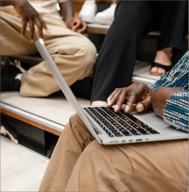 Community members sharing ideas and working on a laptop
